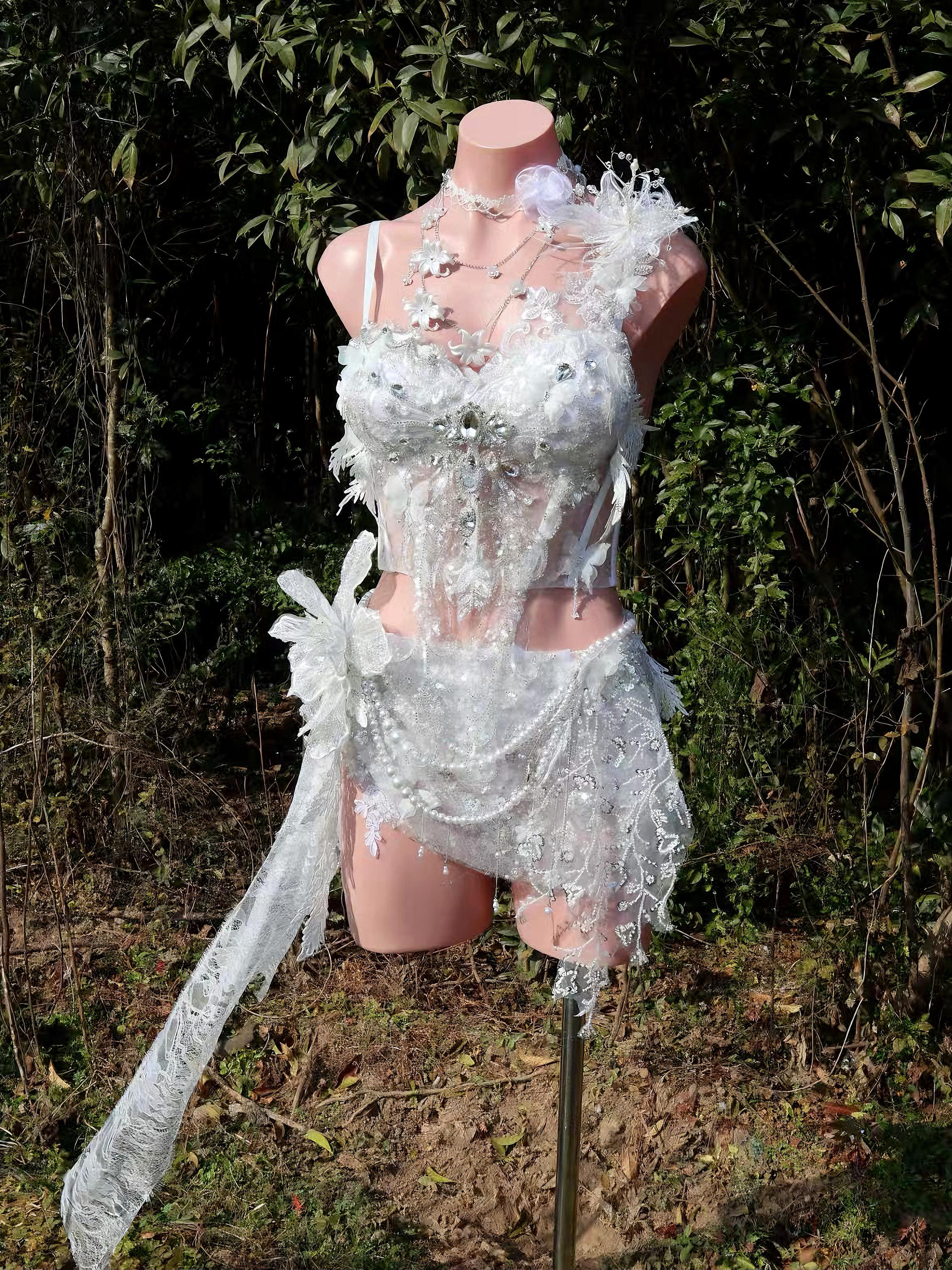 Elegant white lace lingerie set with floral appliqués and sheer detailing, displayed on mannequin outdoors